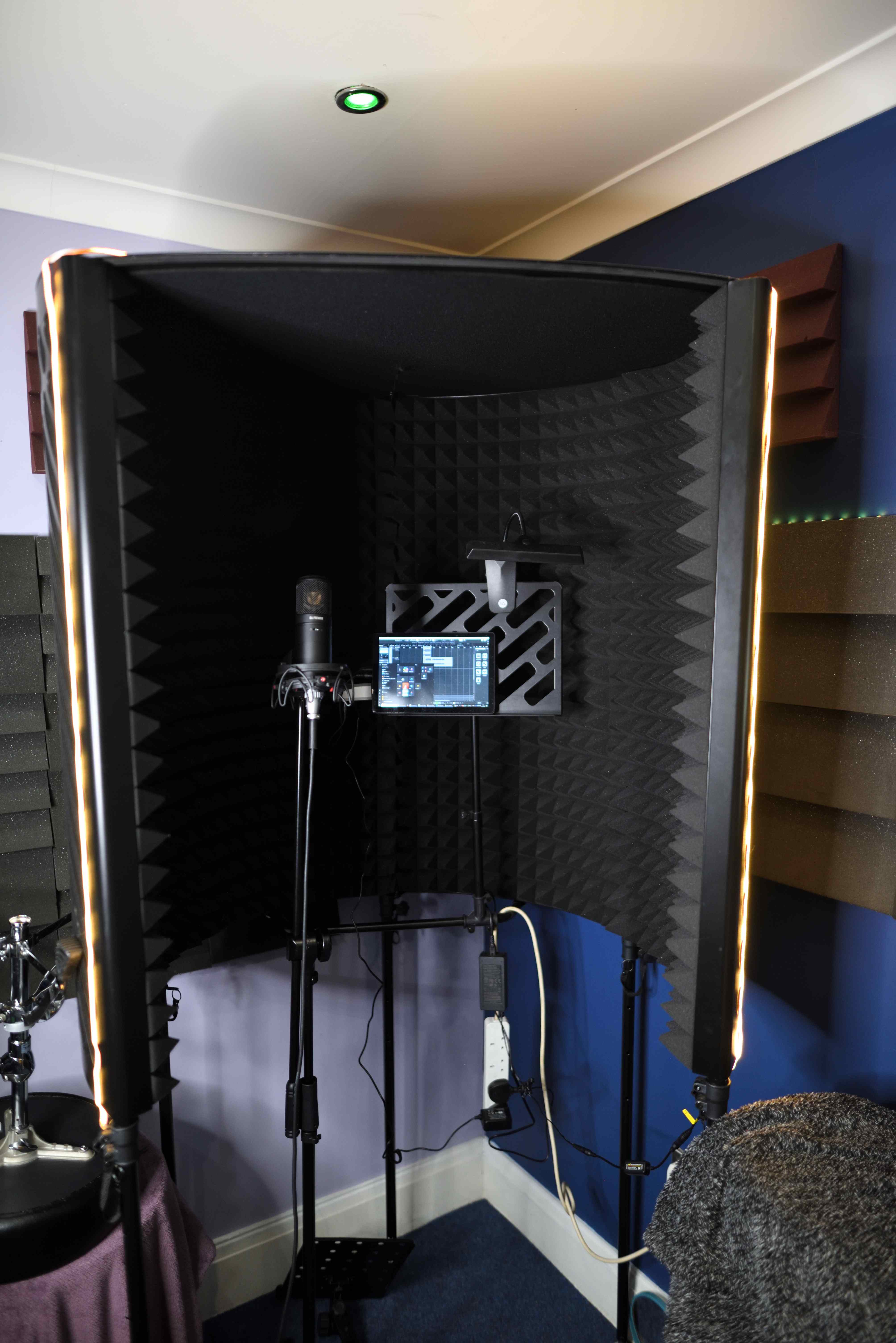 Vocal booth with LED lighting, acoustic treatment and a professional condenser microphone